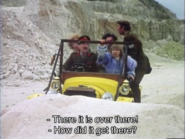 Jon Pertwee (and Patrick Troughton) episode. The Doctor, Jo Grant, Sergeant Benton and others are driving Bessy (the Doctor’s vintage yellow car) through a land in an antimatter universe, as depicted by a quarry in Wales. The Brig yells, “There it is over there!” Jo asks, “How did it get there?” They all get up and start running; caption reads, “That's a very good question, Miss Grant. Come on!”