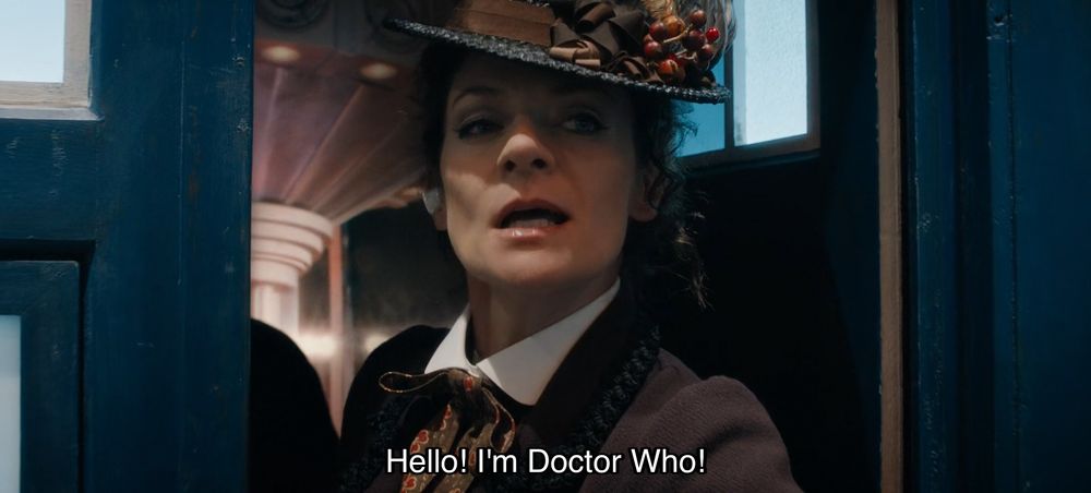 Episode with Peter Capaldi, teenage heartthrob — although, heart-shatteringly, he is not on screen. Instead, Missy is peering out the door of the TARDIS, with a sly smile, wearing an excellent hat with a big bow and some fruit on it. Caption reads, “Hello! I’m Doctor Who!”