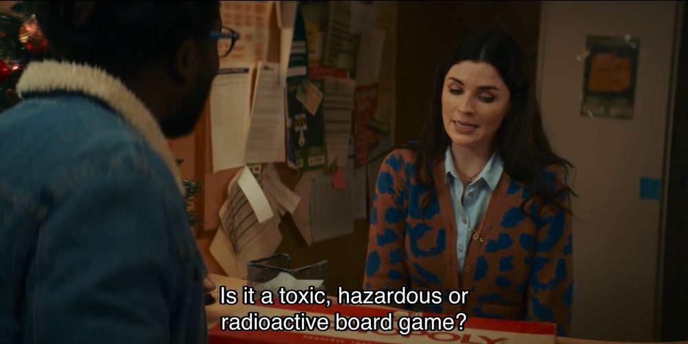 Jodie Whittaker episode. A man and a woman are standing in a lobby late at night; a bunch of papers are pinned to a bulletin board behind the desk. The woman looks thoroughly unimpressed. Maybe she’s a bit miffed that she’s wearing such an ugly blue and orange spotted cardigan. There’s a Monopoly board sitting in the desk between them. Caption reads, “Is it a toxic, hazardous or radioactive board game?”