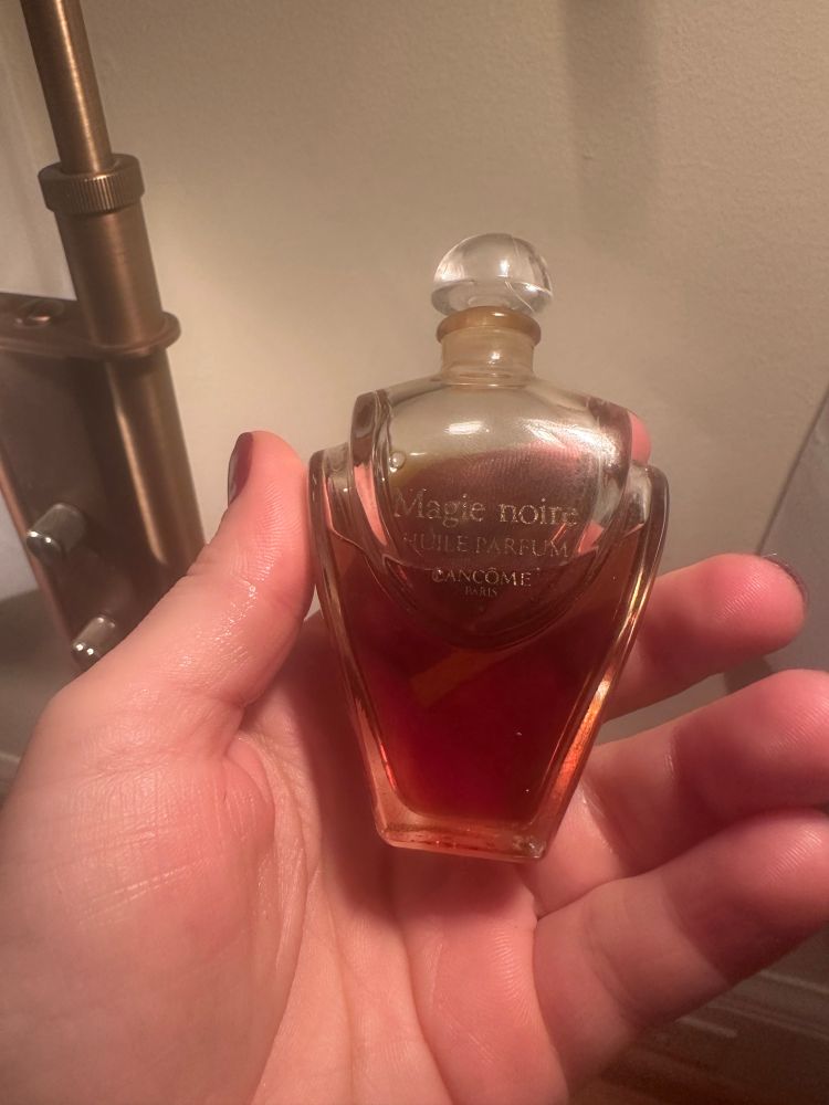 Pepper holds up a bottle of vintage Magie Noire oil perfume by Lancôme. This is one of her favorite scents and was a recent antique mall find! 