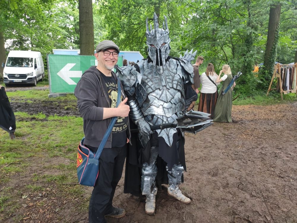 Ich mit einer Schieber Mütze , Kapuzenjacke (offen) und meinem Khazadum Dûm T-Shirt neben einem Sauron Cosplayer in Rüstung mit Streitkolben