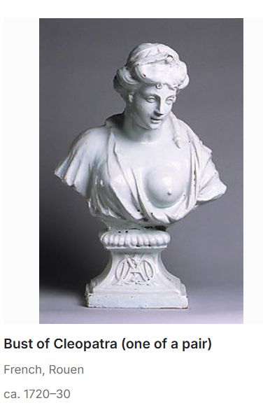 Museum-style photo of an bust of Cleopatra with one boob out. The caption reads "Bust of Cleopatra (one of a pair)" (also says French, Rouen, ca. 1720-30)