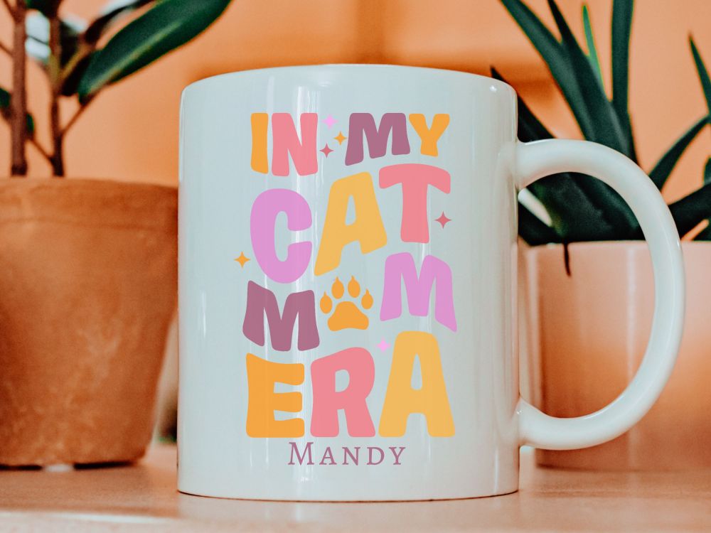 White mug with colourful text that reads in my cat Mom era