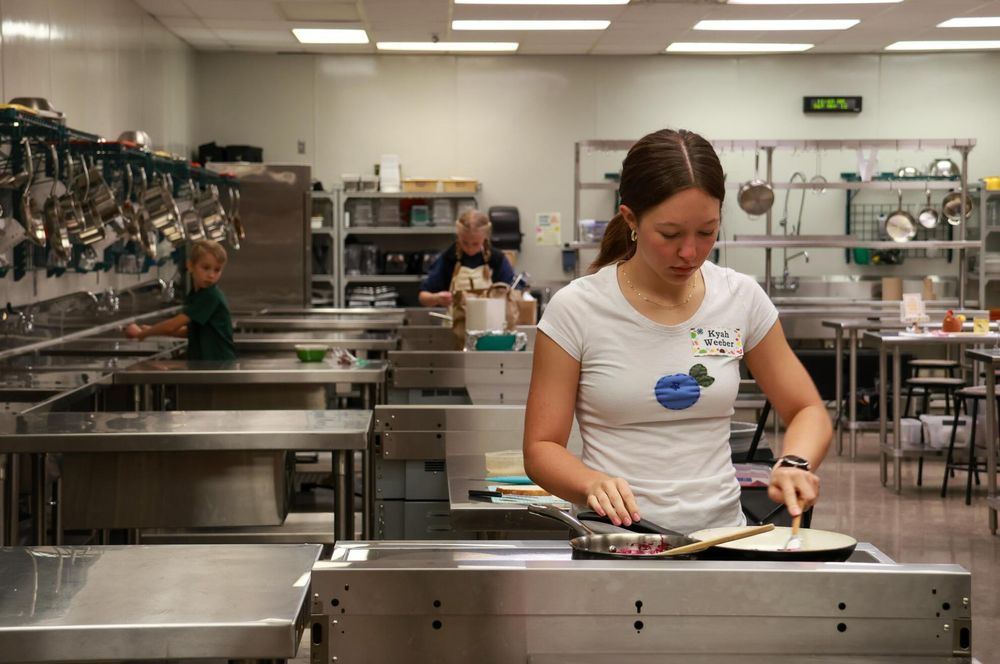 Kyah Weeber, a Philomath High senior, preparing food on a stove.