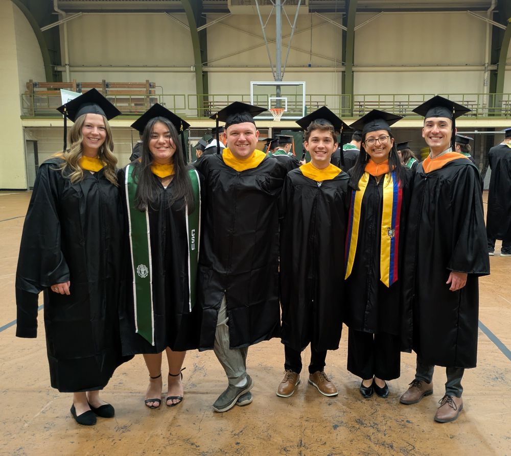 Six people in graduation regalia