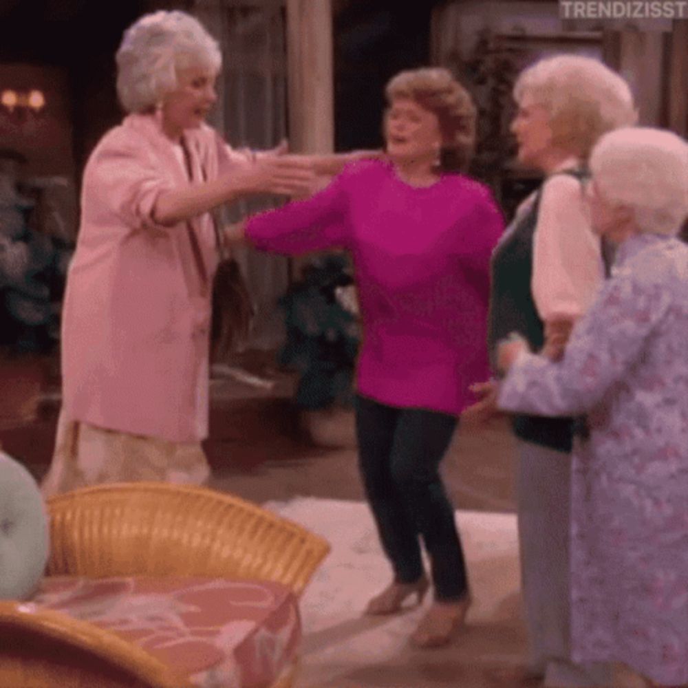 a group of older women are dancing together in a room .