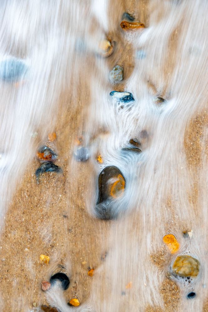 water rushing swiftly over sand and stones