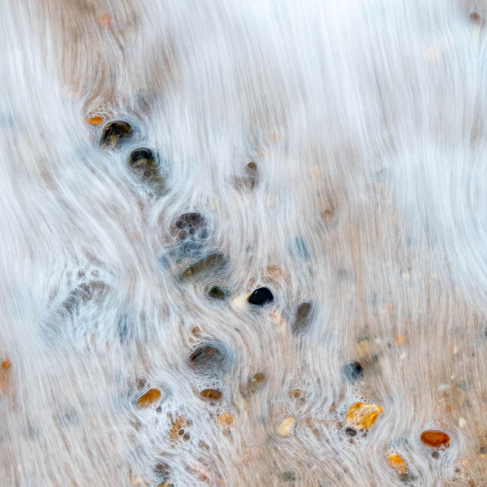 water flowing wetly over pebbles