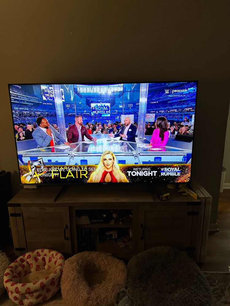 Picture of a TV showing the pre show for the 2025 Royal Rumble with a Charlotte Flair banner at the bottom.