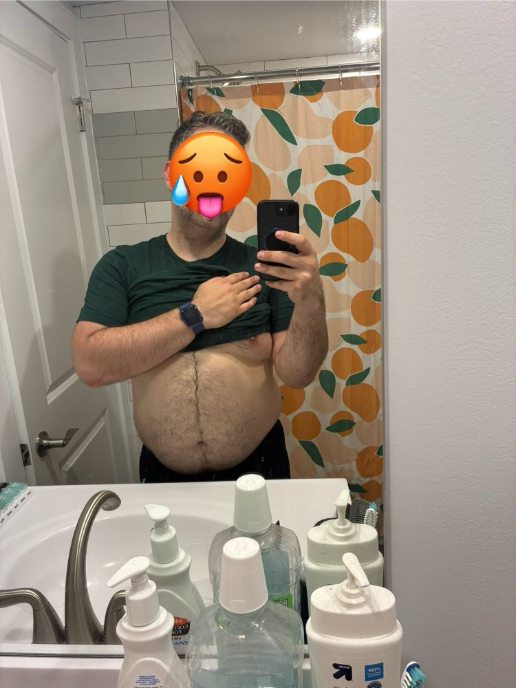 A mirror selfie of myself, with my shirt partly raised to show my belly, with a “sweaty” emoji over my face.