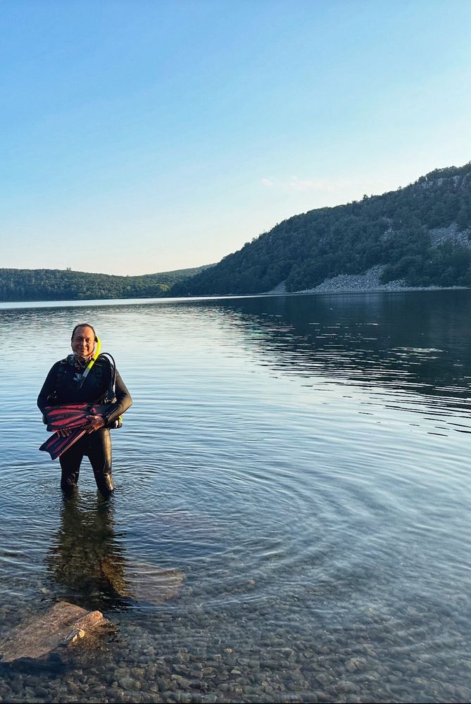 Man in scuba gear standing in a lake