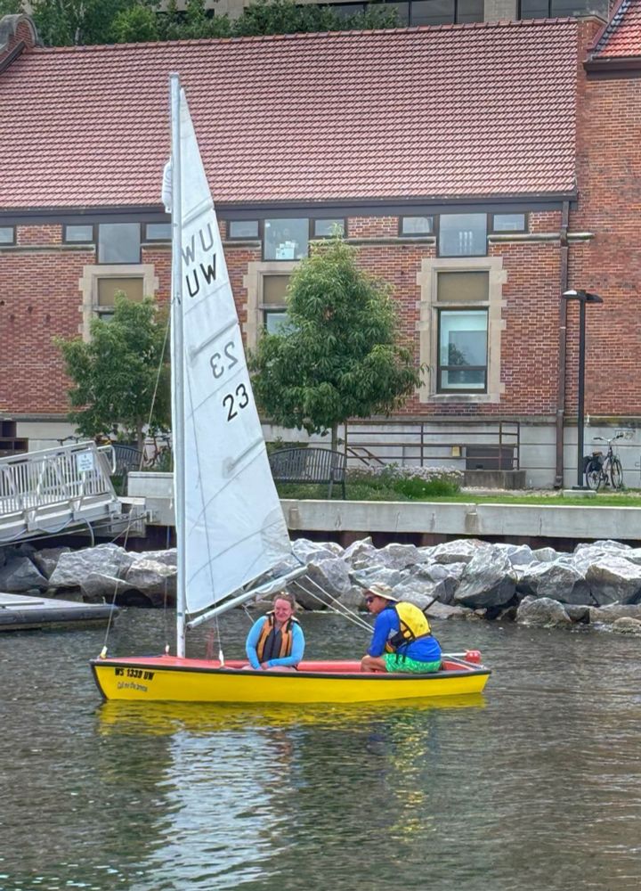 Man and woman docking a dinghy sailboat