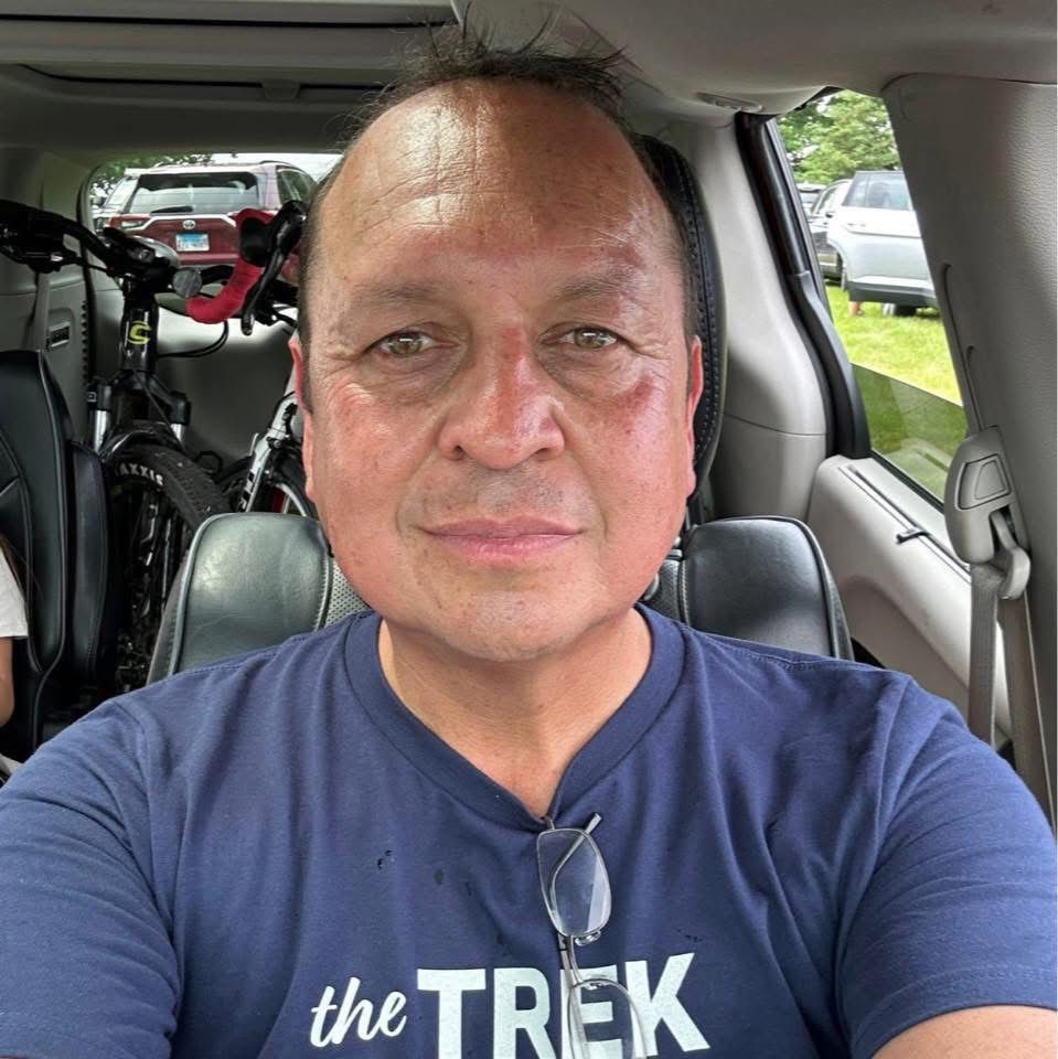 Man sitting in van after a 34 mile bike ride with a Trek Bikes shirt on and bikes in the back of the van.
