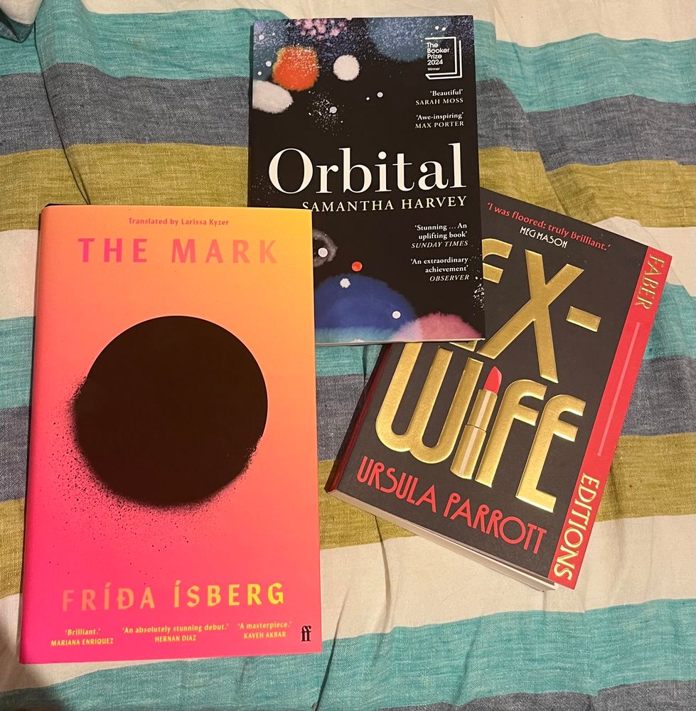 A photo of three books; The Mark by Frida Isberg, Ex-Wife by Ursula Parrott, and Orbital by Samantha Harvey