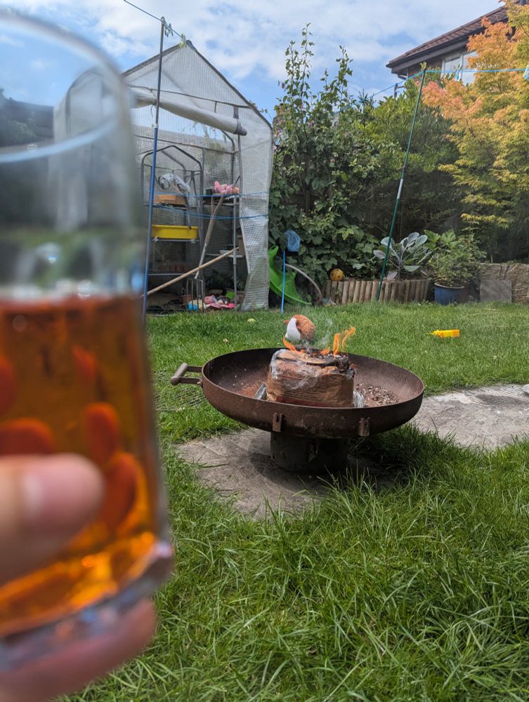 Lighting a barbecue while holding Aperol spritz