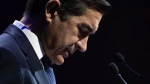 Carlos Torres presidente de BBVA mirando hacia el suelo en un escenario oscuro 