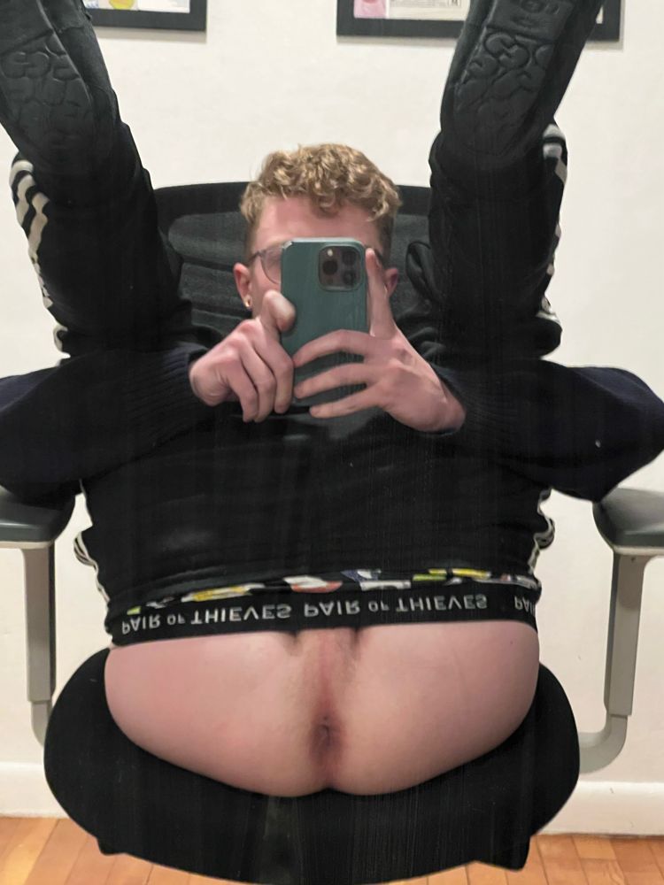 Ian leaned back in a chair with his legs folded up and his pants pulled up exposing his tight hole