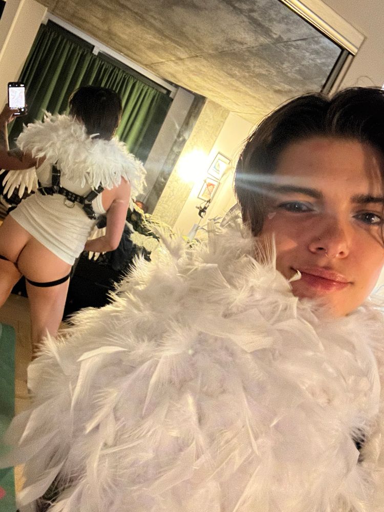 Mirror selfie revealing a butt in a jock with all the fluffy angel wings taking up most of the frame