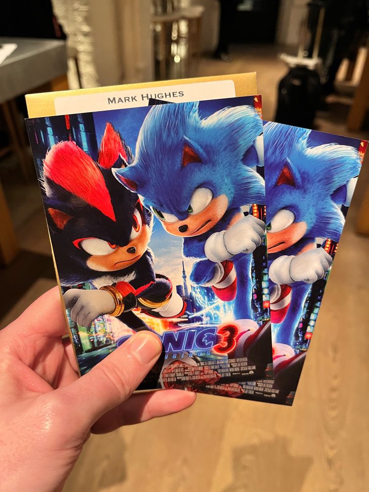 Hand holding two tickets to the Sonic 3 premiere.