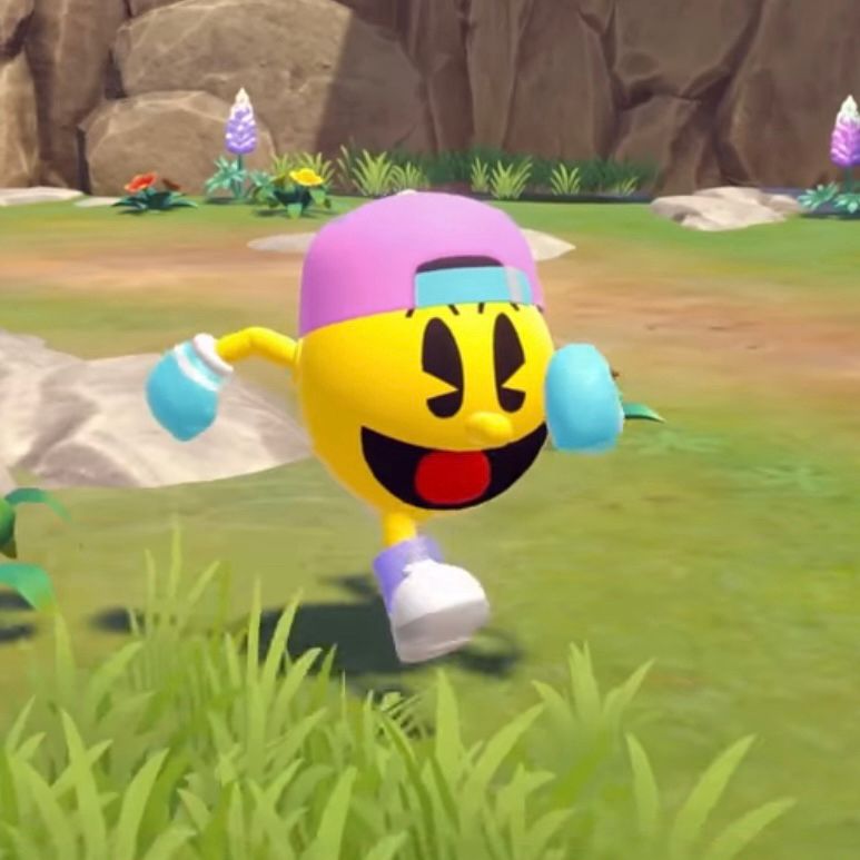 Screenshot from Pac-Man World 2 Re-Pac. Pac-Man is running through a field wearing a pink and blue baseball cap, with light blue gloves and purple trainers