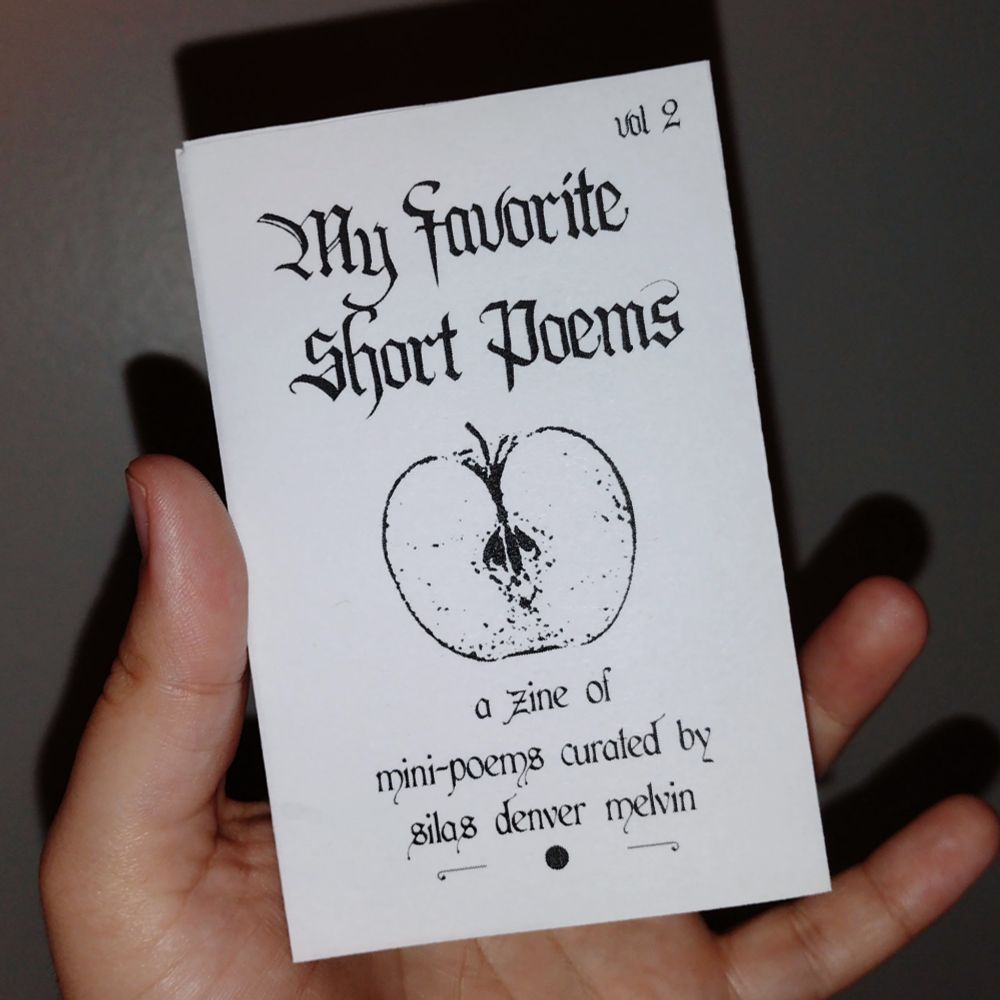 a hand holding up a black and white zine that reads "my favorite short poems" 