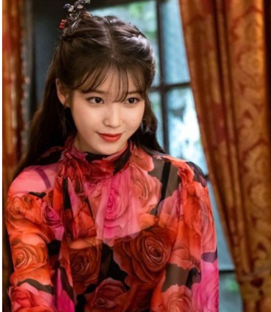 IU wearing a red floral blouse in a scene from the kdrama Hotel del Luna.
