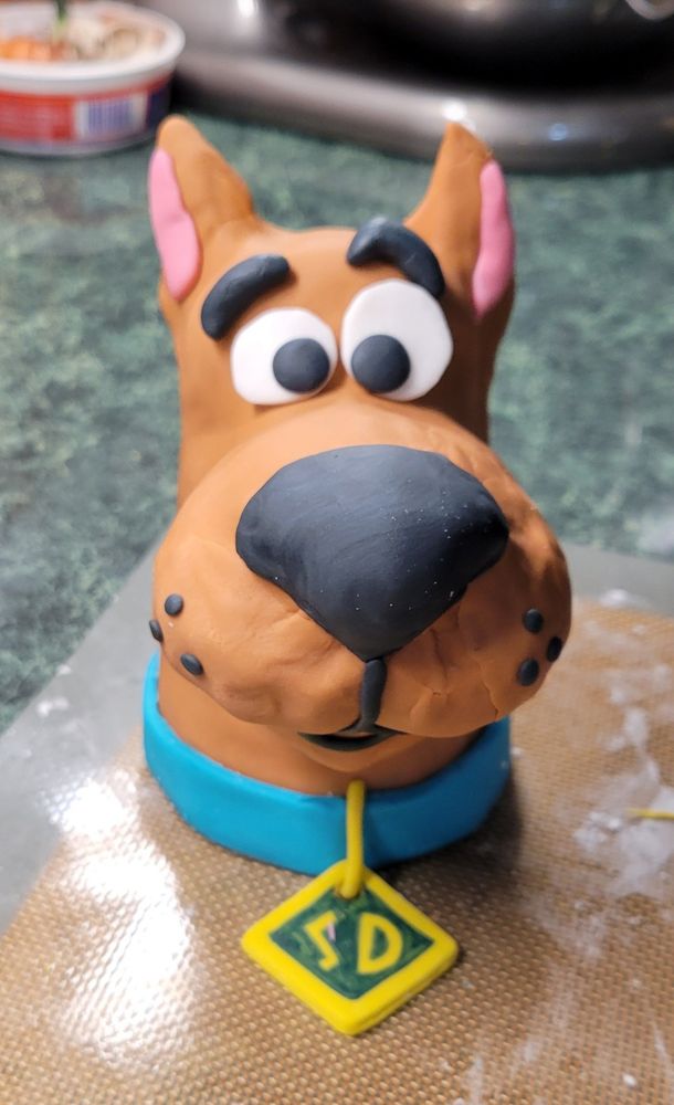 Scooby Doo's head, made of fondant, sitting on a silicone mat on my counter 