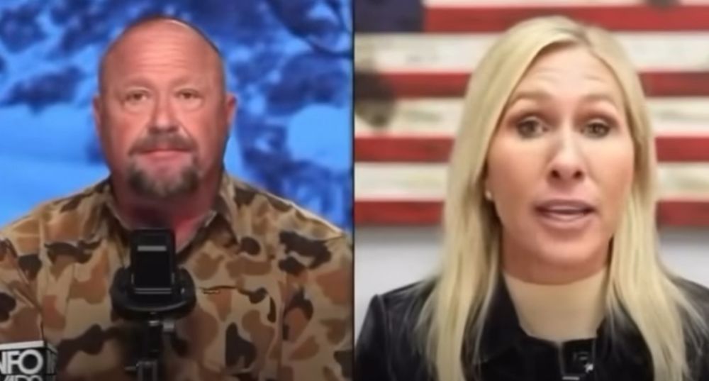 Alex Jones looks like he ate Alex Jones, and MTG looks like she is via satellite in a hostage video.  A Screenshot from InfoWars, which... btw why is that still operating?