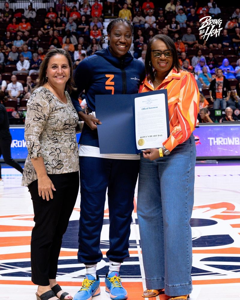Photo of Tina Charles receiving  a $20,000 donation check from Yale New Haven Health for her Hopey's Heart Foundation, via Connecticut Sun.
