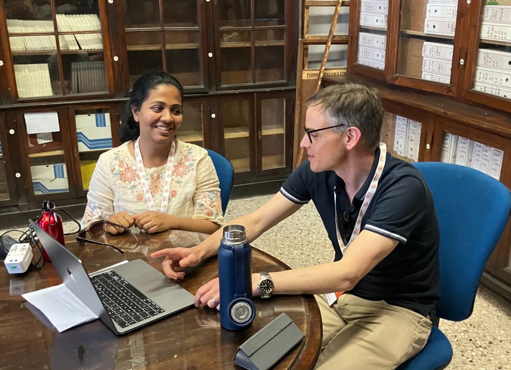 Dr Shraddha Ghatkar and Prof Robin Purshouse seated at a computer at Siena University reviewing the conf presentation