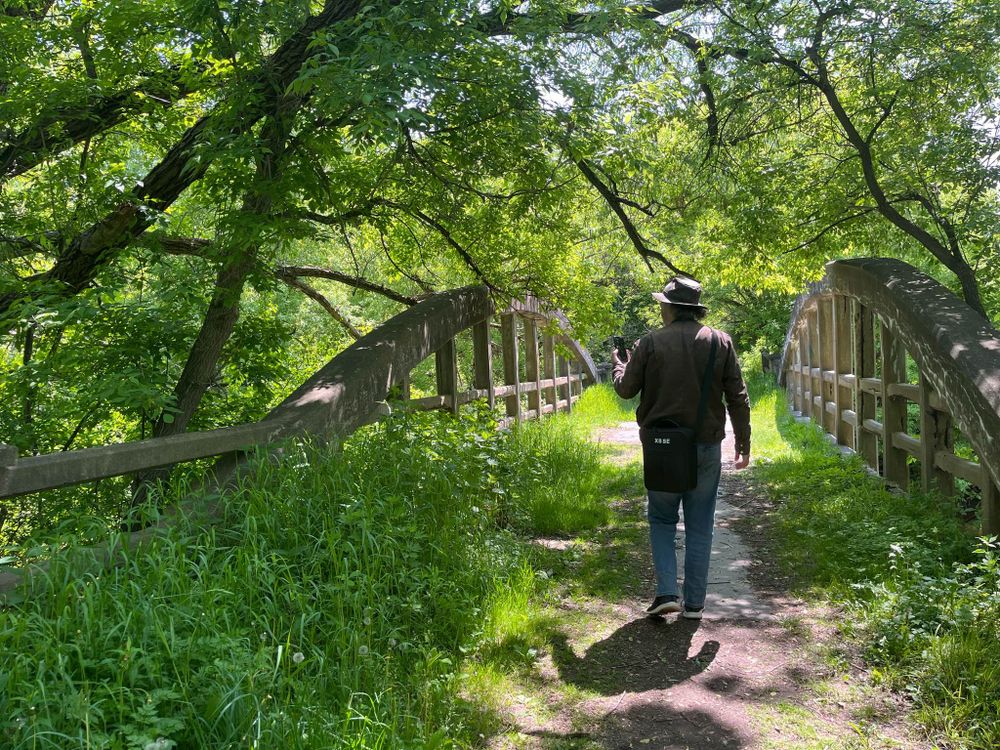 John taking photos on a bridge on a hiking trail.