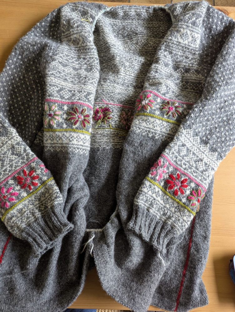 Grey knitted cardigan with coloured  flowers embroidered on sleeves and body