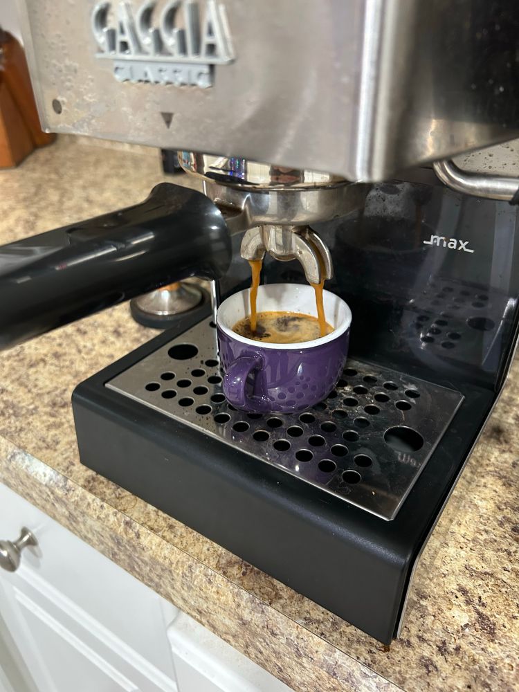 Espresso brewing into a purple cup