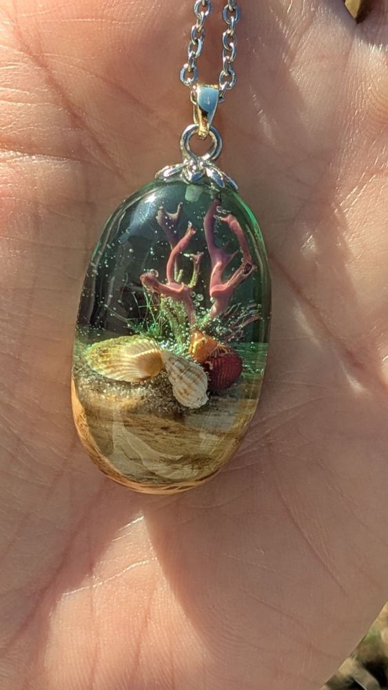 Pendentif Galet de résine et bois avec une mini scène corallienne et des coquillages 