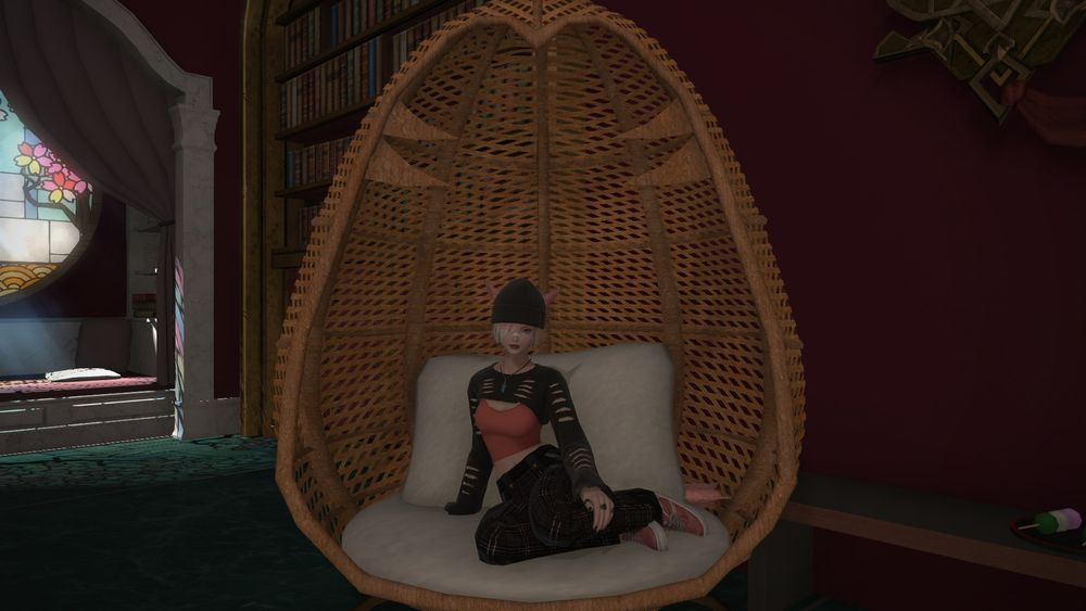 A pink hair Mi'qo (cat girl) sitting in comfy clothes just hanging out