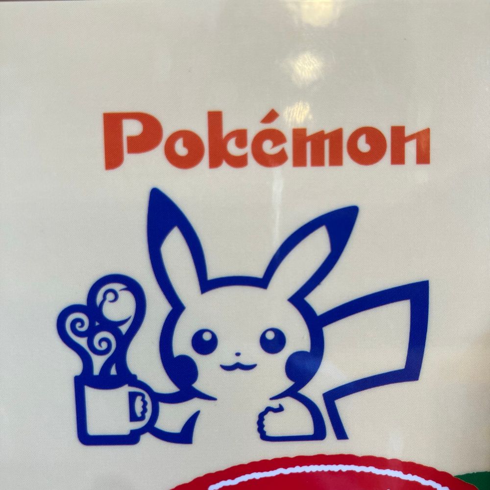 Pikachu holding a cup of Komeda’s coffee. Vapor from the drink is shaped like a pokeball. 