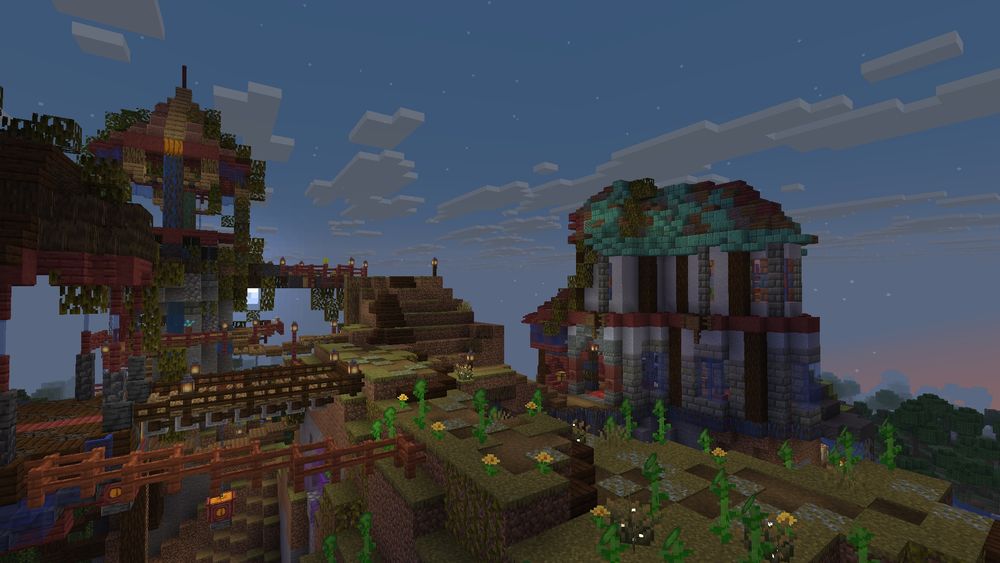 A screenshot from my Minecraft single player world, which is called Jerascape. This is the opposite side of the building in the previous picture, and you can see the taller section of the building better here. The building is mostly in shades of red and blue, with some shades of brown as well. The side that's facing us is largely very light blue, and has a mostly green copper roof. To the left in the foreground, you can see two of the other gazebo-like buildings from earlier in this world.