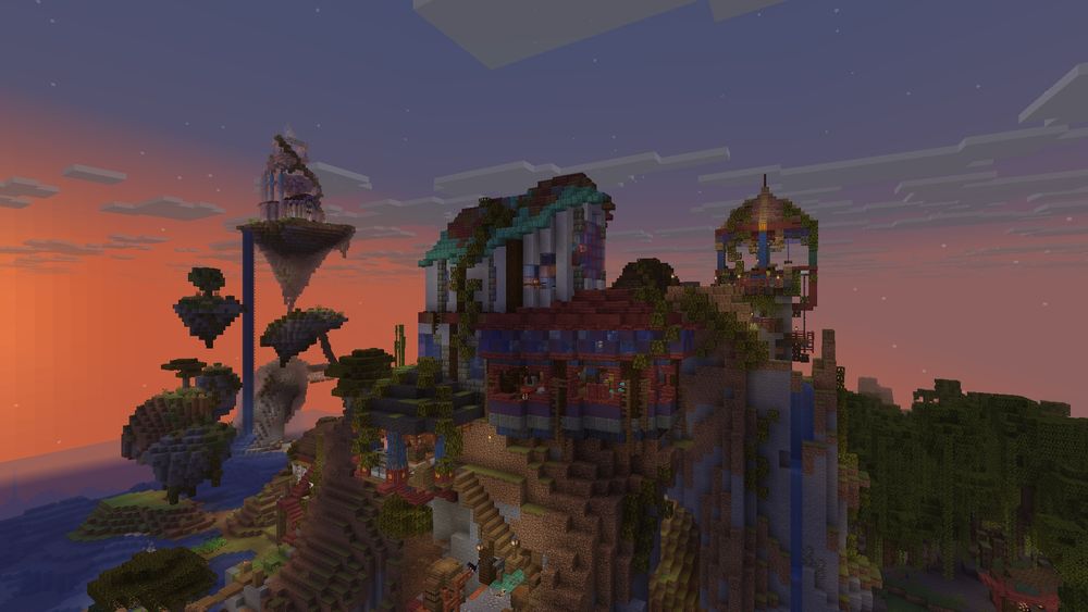 A screenshot from my Minecraft single player world, which is called Jerascape. The sun is setting, and in the foreground you can see the main building I'm referring to. The building is mostly in shades of red and blue, with some shades of brown as well. There is a terrace on one side with a lot of wide openings, and on the other side the building is taller and opens into a second floor. I'm not very good at describing buildings, apologies. In the background you can see some floating islands, and my initial gazebo from this world.