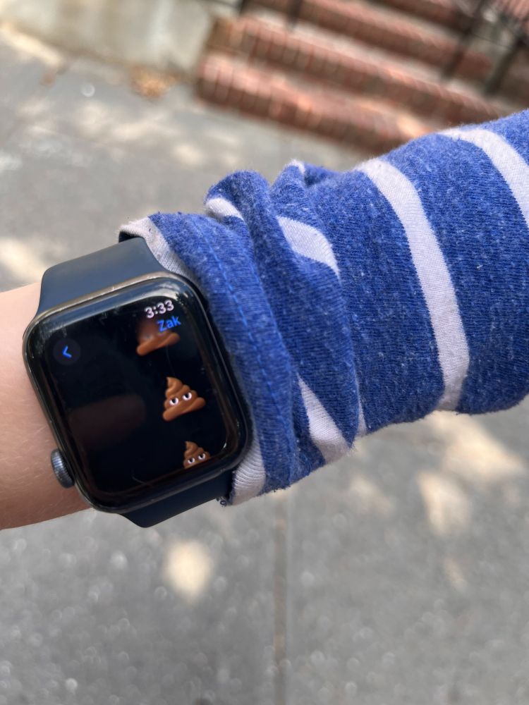 Photo of a kid's wrist with AppleWatch displaying many poop emojis.