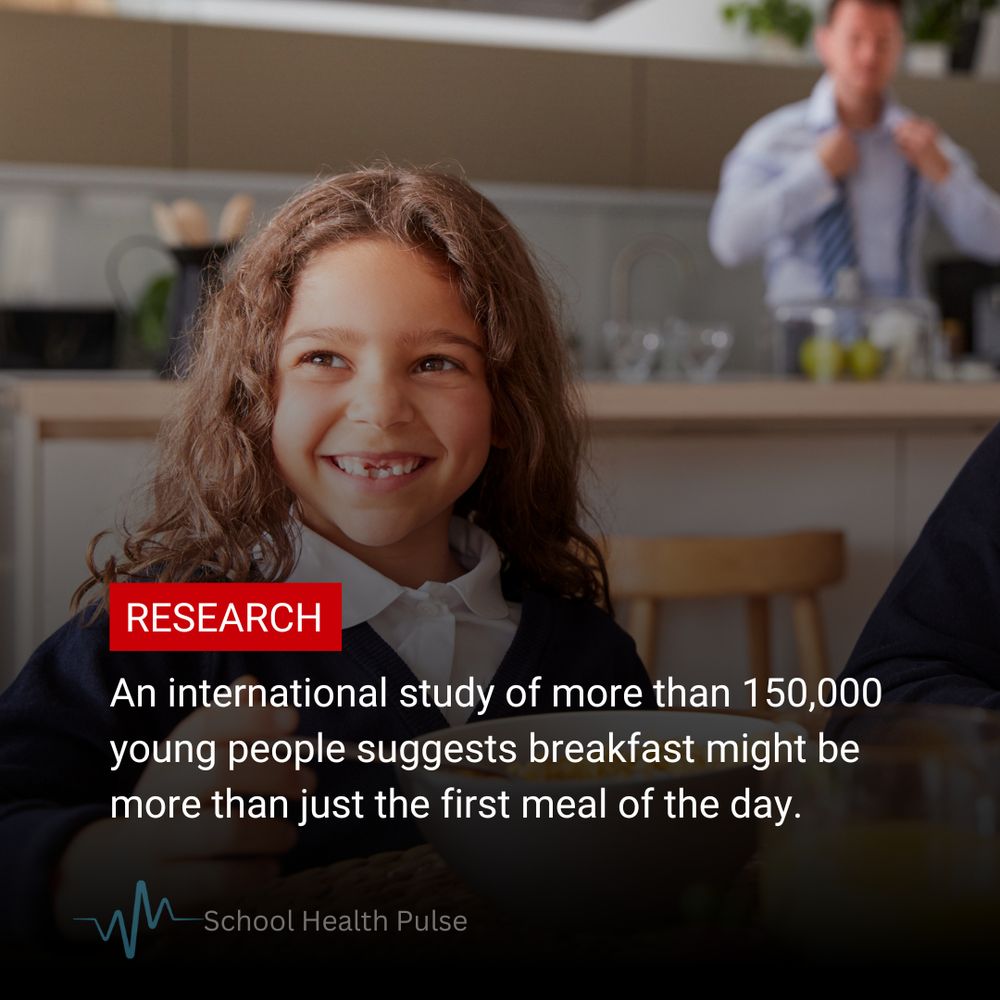 Young girl in school uniform sits at table in front of a bowl of cereal
