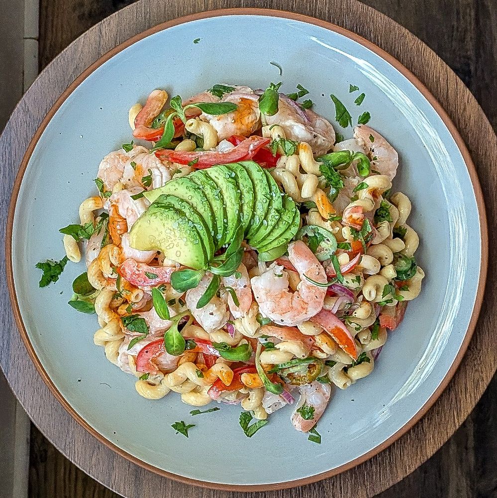 Cold shrimp pasta salad on a round blue plate topped with sliced avocado. 

Ingredients: 

Cooked shrimp
Banza chickpea pasta
Red onion
Red bell pepper
Serrano pepper
Cilantro
Avocado 
Cholula extra hot
Olive oil mayo
Lime juice
Salt
Pepper 
Slap ya mama