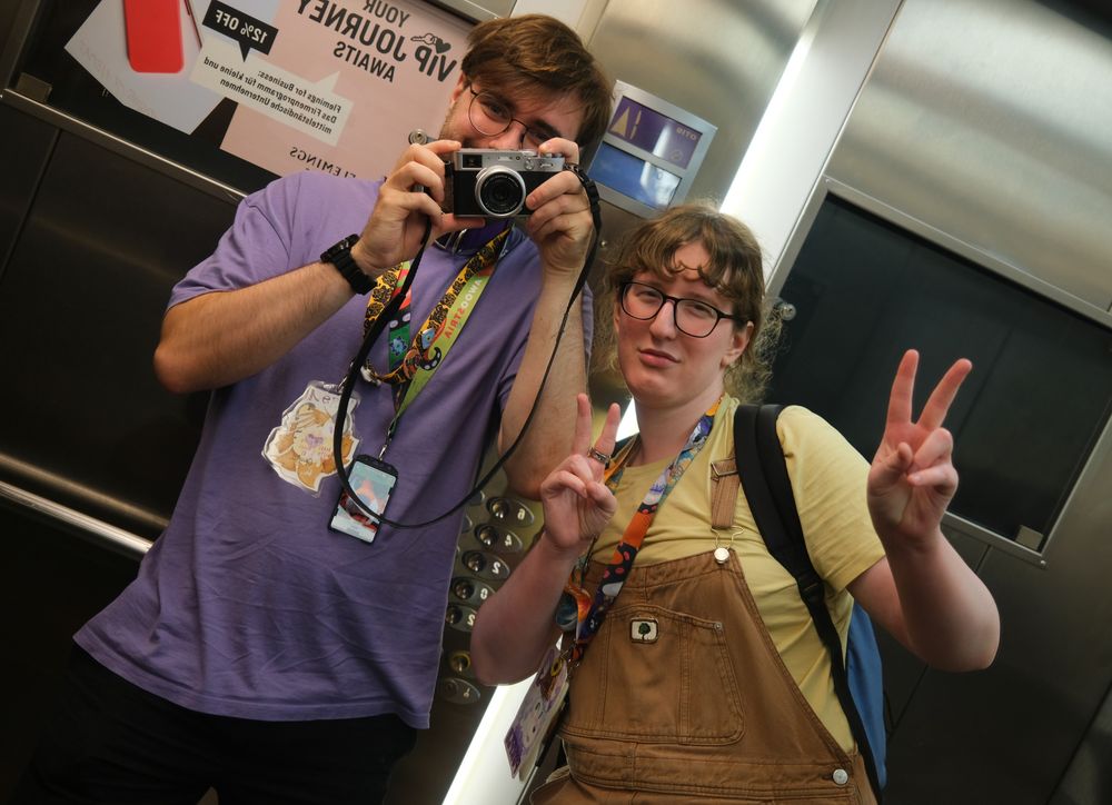 Picture of me and Purple, taken in the mirror of an elevator. I'm holding the camera, purple is holding up peace signs with both her hands. The picture is taken at a slightly slanted angle for aesthetical reasons