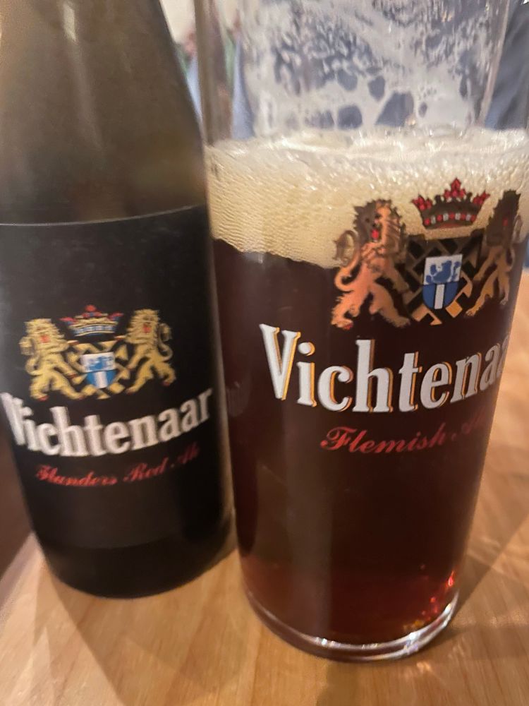 A half pint glass and a bottle both bearing the word Vichtenaar. They contain a very dark beer.