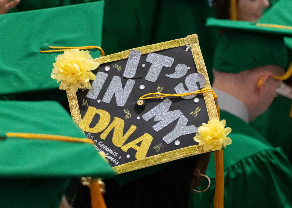 The top of someone's cap is decorated to read "It's in my DNA!"
