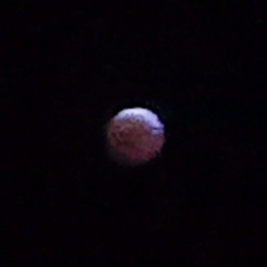 a grainy photo of the blood moon lunar eclipse, zoomed in