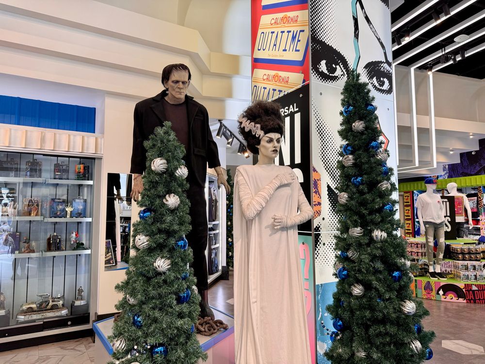 Frankenstein’s Monster and Bride of Frankenstein posing with festive Christmas Trees at Universal Studios Orlando