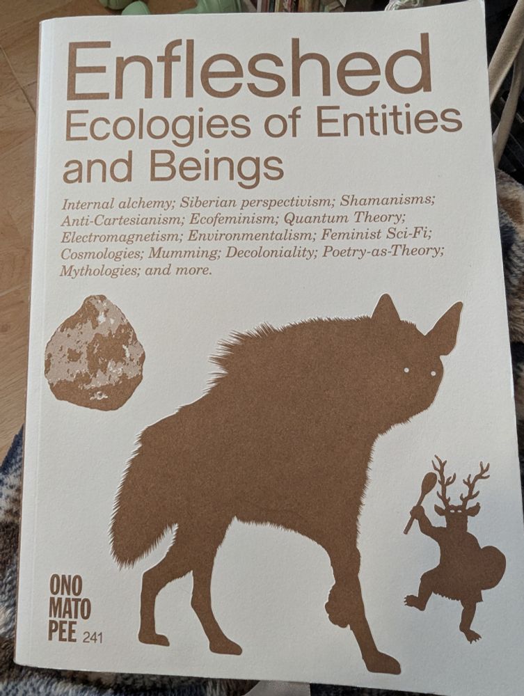 A picture of a books titled Enfleshed: Ecologies of Entities and Beings - a hyena dominates the centre of the books, flanked by a rock and a dancing animal-headed shamanic figure. 