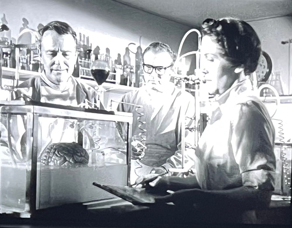 Two men and a woman in a lab observe Donovan’s brain in a tank. They knew it’s Donovan’s because it sang “Season of the witch.”