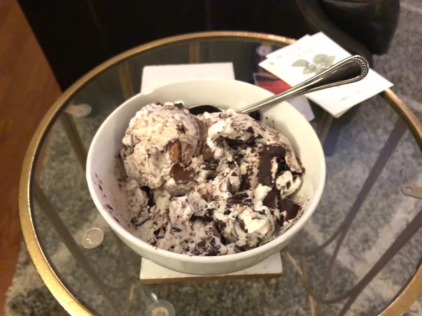 A bowl of Moose Tracks ice cream - vanilla ice cream with chocolate fudge swirl and peanut butter cups.