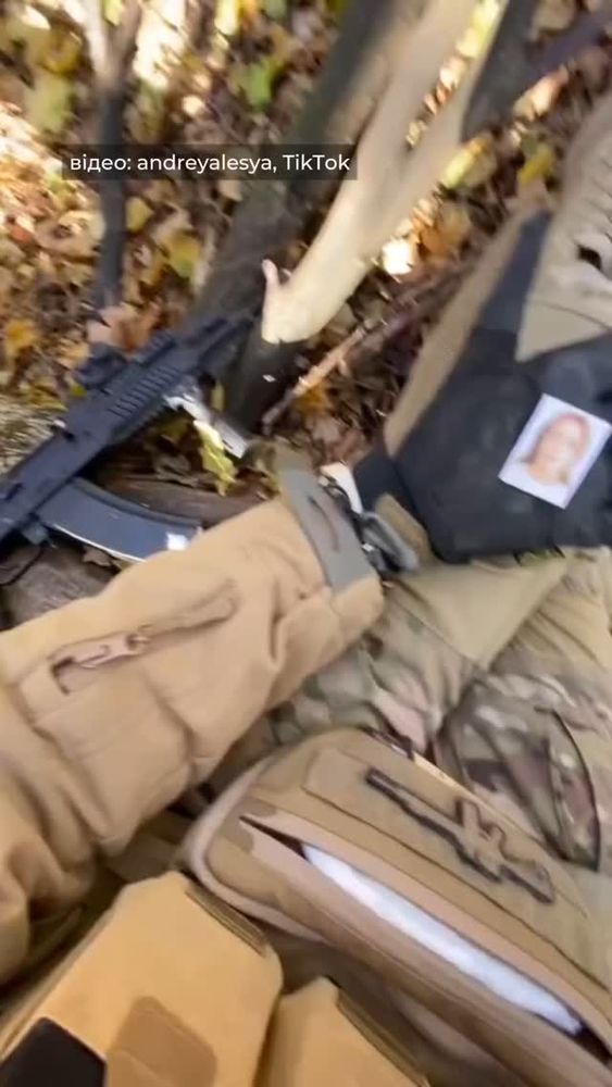 A Ukrainian soldier taking a break with his girlfriend, child, sister, or wife's photo in his hand.  No context was given as to which the photo represents to the soldier